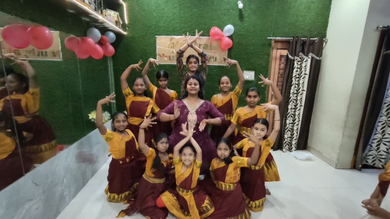 Young dancers arranging themselves in a classical group pose inside the studio