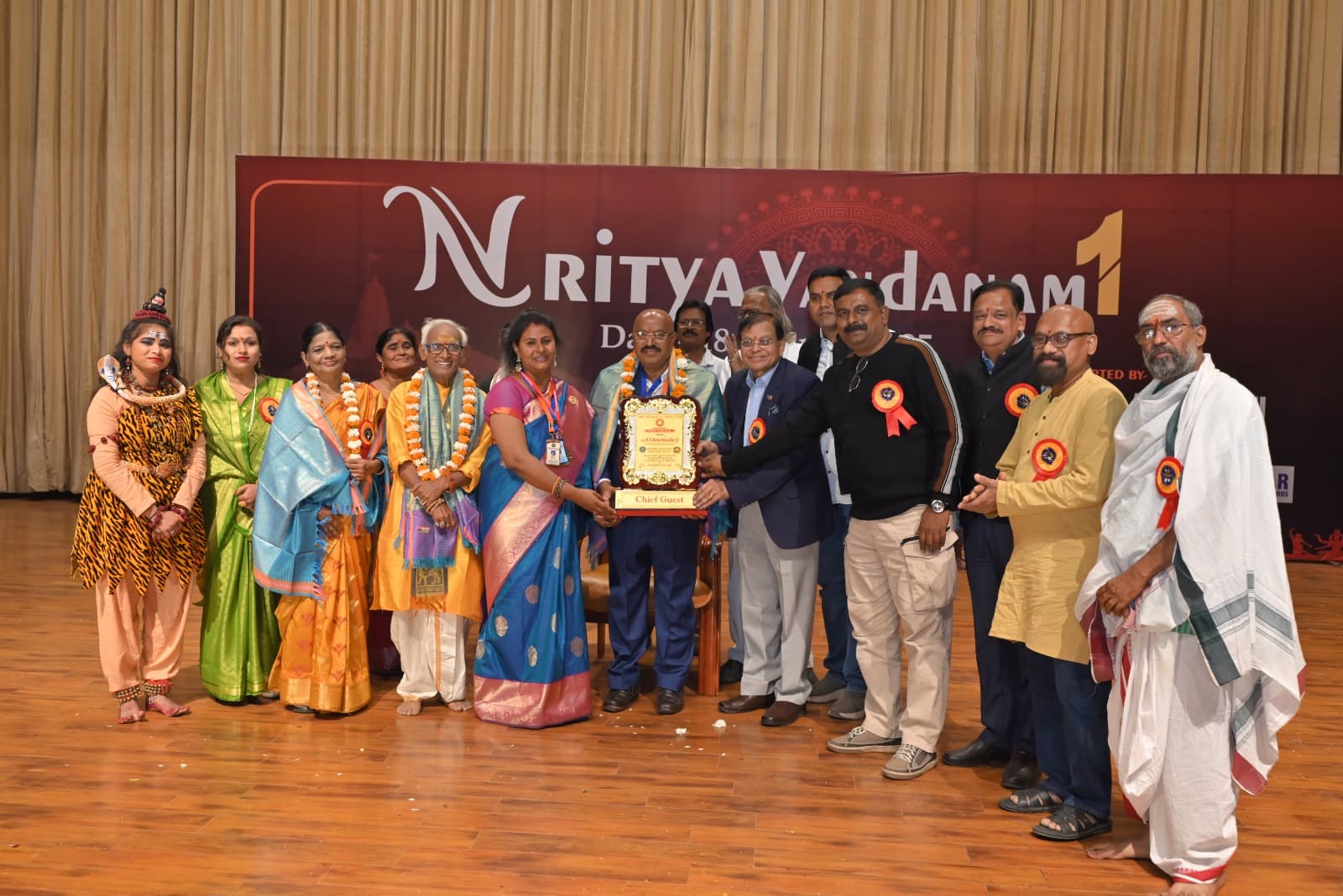 A group holding an award on the Nritya Vandanam stage