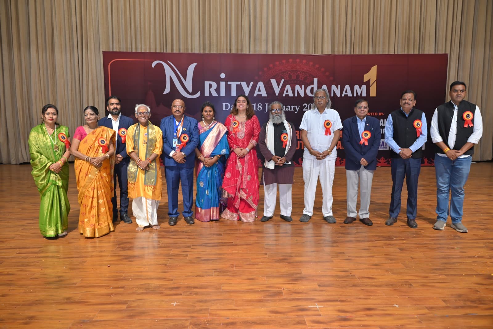 Participants and guests on stage beneath the Nritya Vandanam banner
