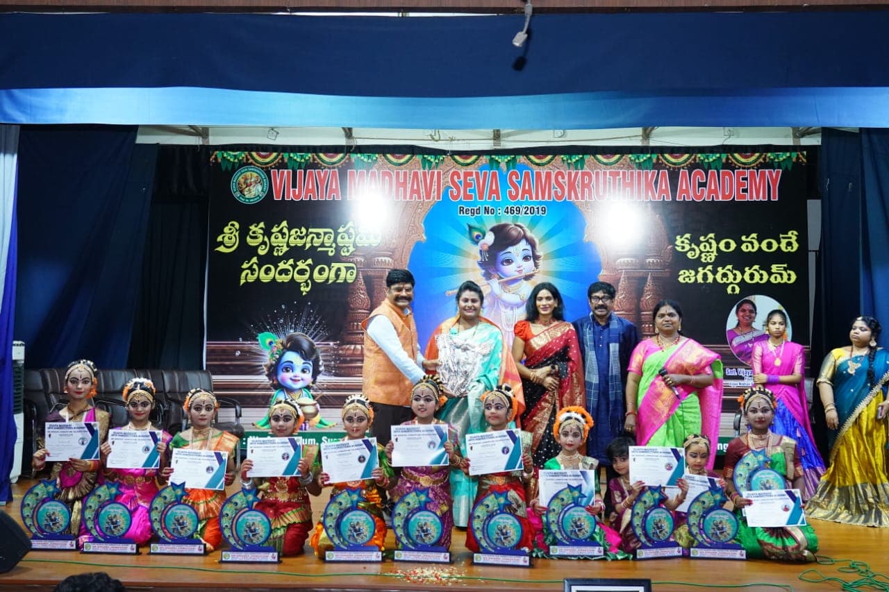 Students holding certificates and awards on a cultural stage
