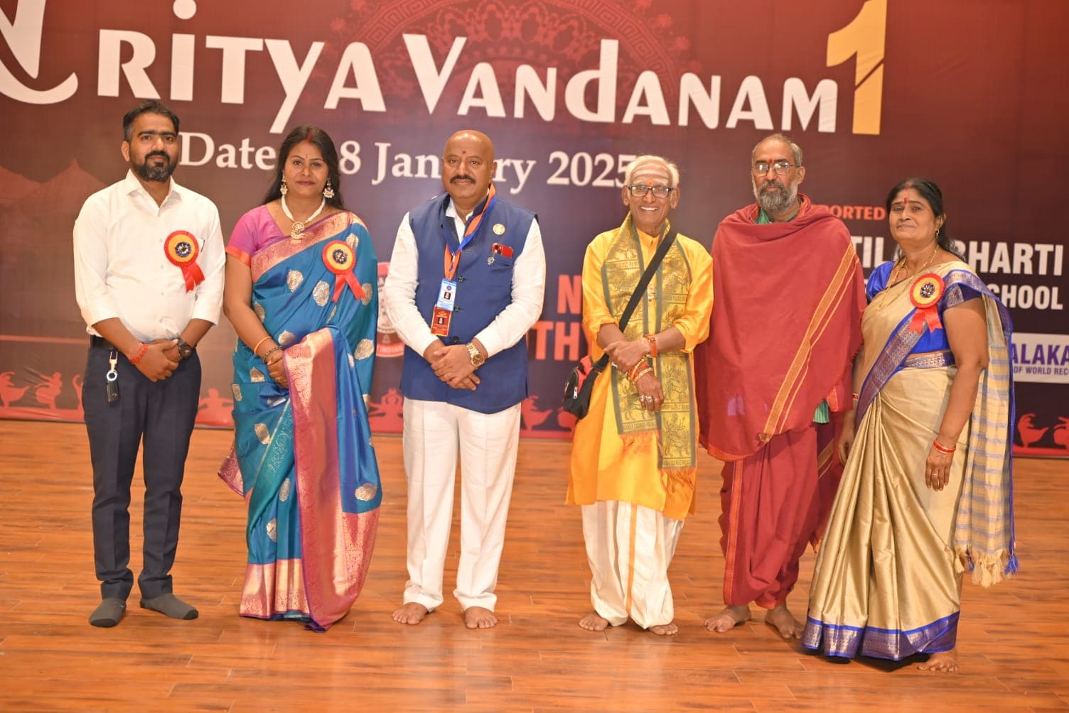 Guests presenting a plaque beneath the Nritya Vandanam banner